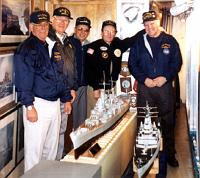  Photo taken at the U.S. Navy Cruisers Association display on board the USS Salem (CA-139), located at the United States Shipbuilding Museum, Quincy, Massachusetts. Standing in back of the newly acquired model of the USS Macon; Paul Sfreddo, President, USS Macon Veteran's Association; Harold Foley, past President and former Treasurer, Macon Association; Ed August, Treasurer, Cruiser Sailors Association; Bill Hennessey, President Massachusetts Chapter, Cruiser Sailors Association; and Bud Johnson, Treasurer, Macon Association.